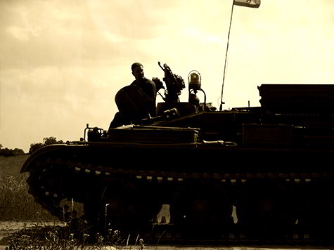 Kamerad sitzt auf einem Panzer